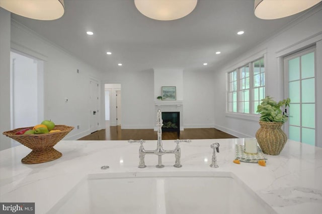 kitchen with recessed lighting, open floor plan, a glass covered fireplace, and wood finished floors