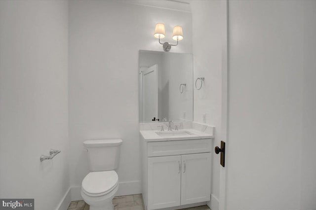 bathroom featuring baseboards, vanity, and toilet