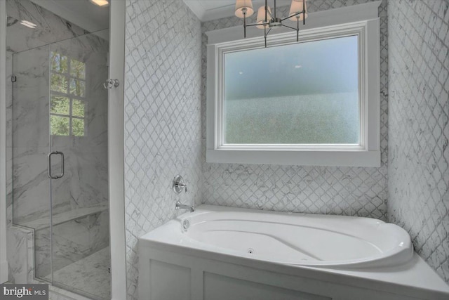 full bathroom featuring an inviting chandelier, a marble finish shower, and a garden tub