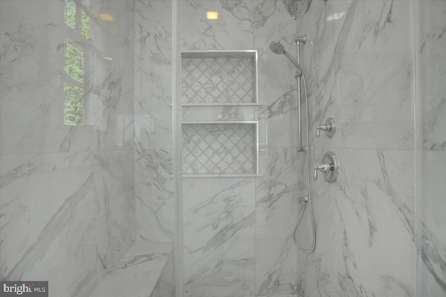 bathroom featuring a marble finish shower