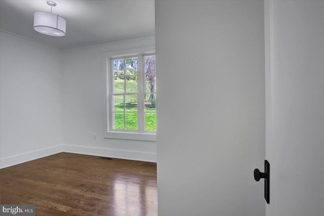 unfurnished room featuring crown molding, baseboards, visible vents, and dark wood-type flooring