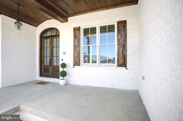 doorway to property featuring brick siding and french doors