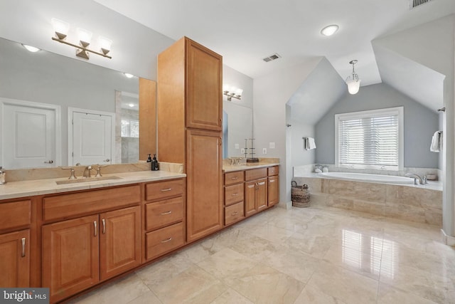 bathroom featuring visible vents, a garden tub, vaulted ceiling, and vanity