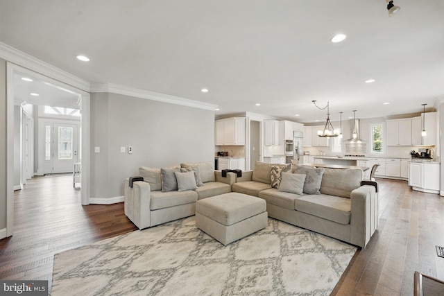 living area featuring ornamental molding, recessed lighting, and wood finished floors