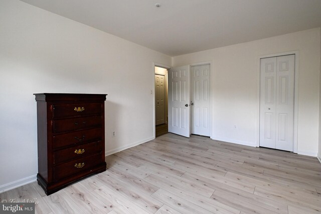 19142 Highstream Dr Unit 679, Germantown, MD 20874 - unfurnished bedroom with multiple closets, baseboards, and light wood-type flooring