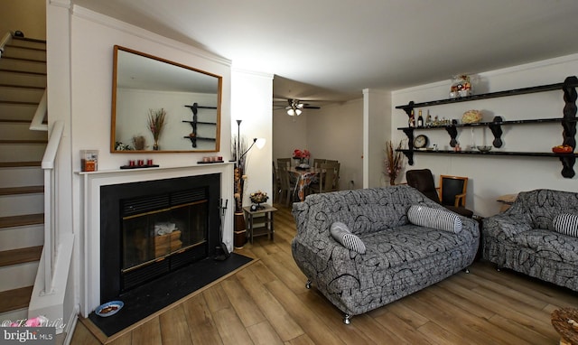 19142 Highstream Dr Unit 679, Germantown, MD 20874 - living room featuring ceiling fan, a glass covered fireplace, wood finished floors, and stairway