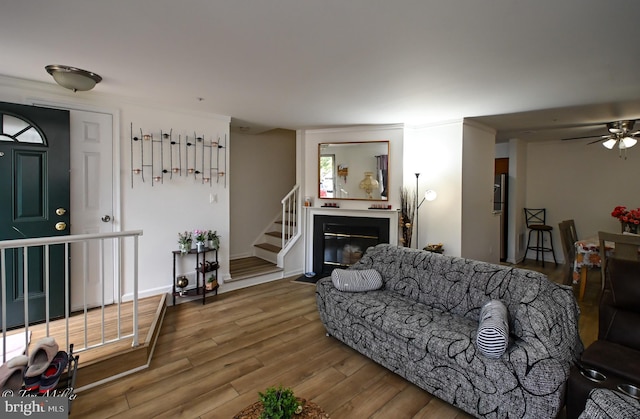 19142 Highstream Dr Unit 679, Germantown, MD 20874 - living room with stairs, a ceiling fan, a fireplace with flush hearth, and wood finished floors