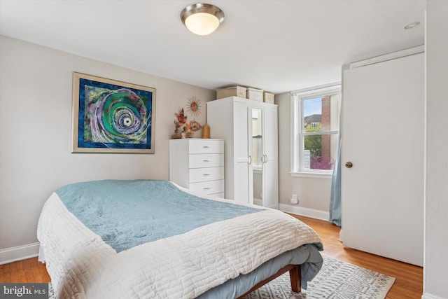 bedroom with baseboards and light wood finished floors