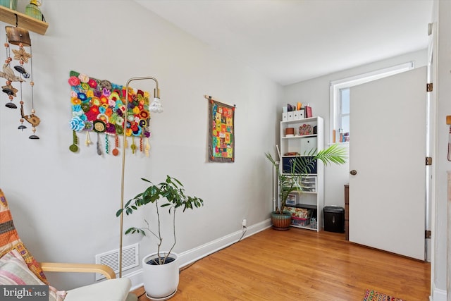 interior space with baseboards, light wood finished floors, and visible vents