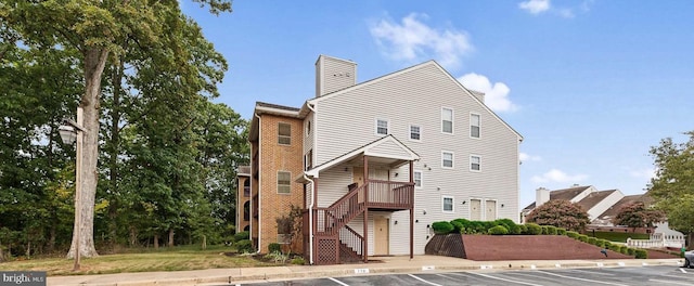 8818 Tanglewood Ln, Manassas, VA 20110 - view of front of home with uncovered parking, a chimney, brick siding, and stairs