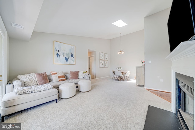 8818 Tanglewood Ln, Manassas, VA 20110 - living area with a fireplace with flush hearth, visible vents, lofted ceiling with skylight, baseboards, and carpet flooring