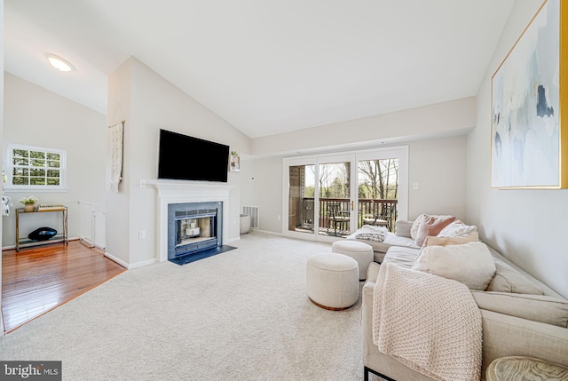 8818 Tanglewood Ln, Manassas, VA 20110 - living room featuring a fireplace with flush hearth, baseboards, visible vents, lofted ceiling, and carpet floors