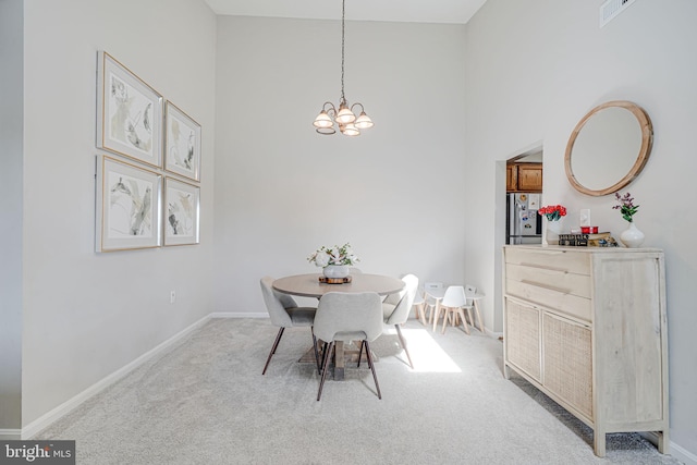 8818 Tanglewood Ln, Manassas, VA 20110 - dining room featuring a towering ceiling, an inviting chandelier, visible vents, baseboards, and light colored carpet