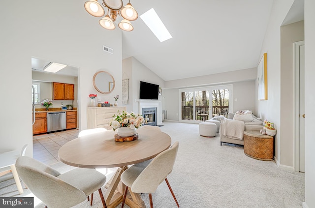 8818 Tanglewood Ln, Manassas, VA 20110 - dining space with high vaulted ceiling, a skylight, a fireplace with flush hearth, light carpet, and baseboards