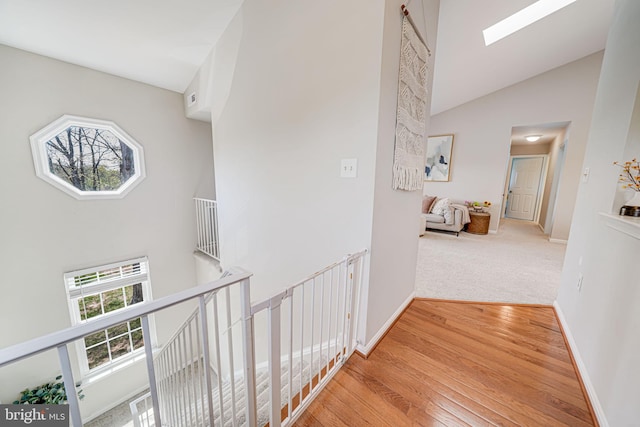 8818 Tanglewood Ln, Manassas, VA 20110 - corridor with baseboards, an upstairs landing, a skylight, wood finished floors, and high vaulted ceiling