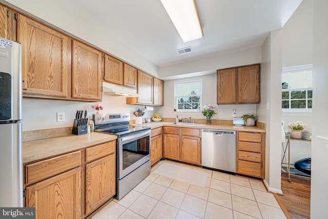 8818 Tanglewood Ln, Manassas, VA 20110 - kitchen featuring under cabinet range hood, stainless steel appliances, light countertops, visible vents, and a sink