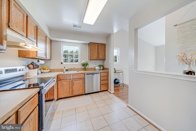 8818 Tanglewood Ln, Manassas, VA 20110 - kitchen with stainless steel appliances, light countertops, visible vents, light tile patterned floors, and a sink