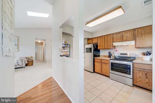 8818 Tanglewood Ln, Manassas, VA 20110 - kitchen with vaulted ceiling with skylight, appliances with stainless steel finishes, light countertops, under cabinet range hood, and visible vents