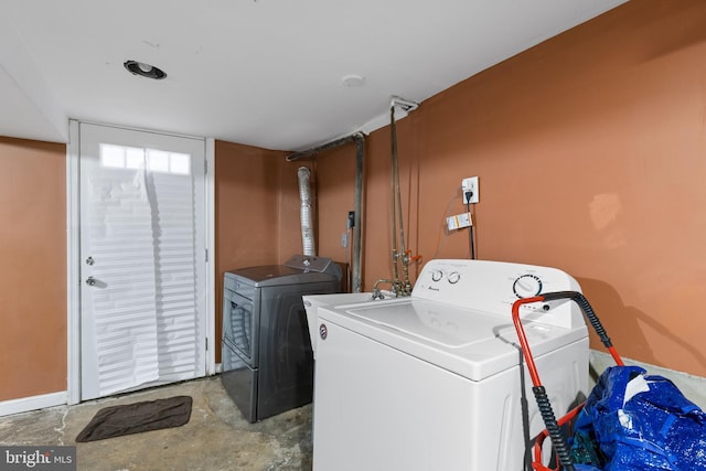 washroom featuring washer and clothes dryer and baseboards