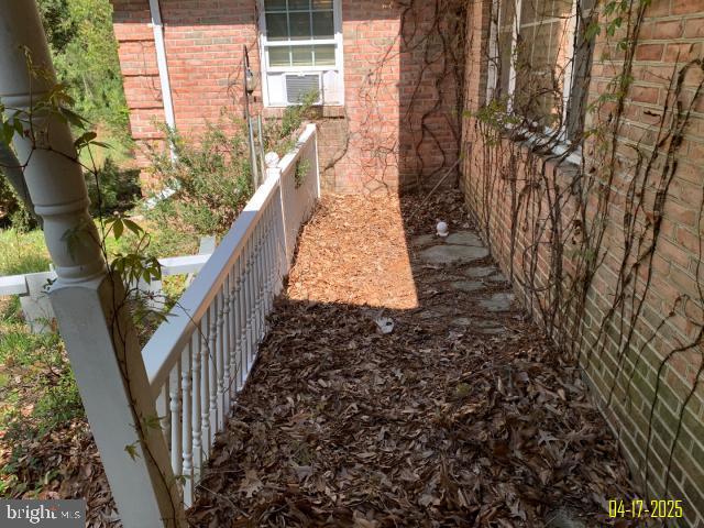 view of side of property with fence and brick siding