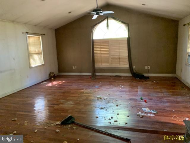 spare room featuring vaulted ceiling, hardwood / wood-style floors, baseboards, and ceiling fan