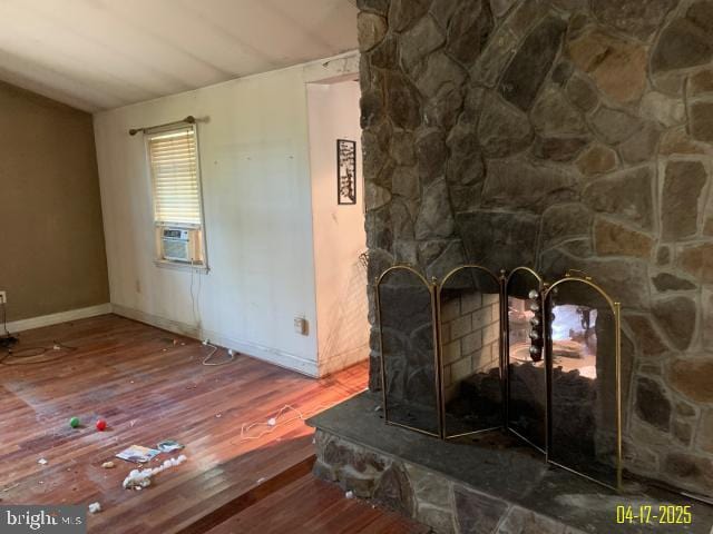 room details featuring cooling unit, baseboards, and wood finished floors