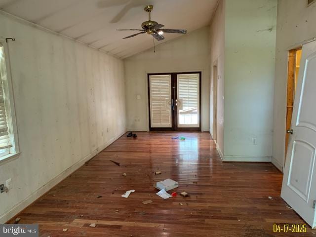 unfurnished room featuring wood-type flooring, vaulted ceiling, a ceiling fan, and baseboards