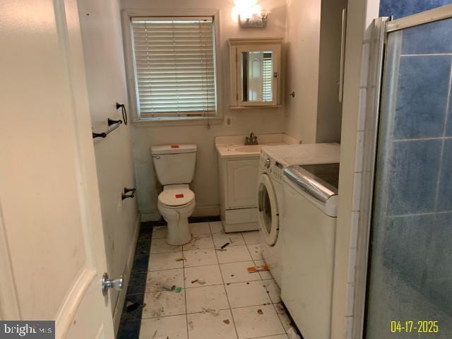 full bath featuring vanity, independent washer and dryer, a shower with door, and toilet