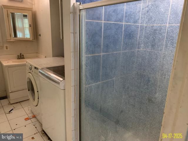 bathroom with vanity, washing machine and clothes dryer, tile patterned flooring, and a stall shower