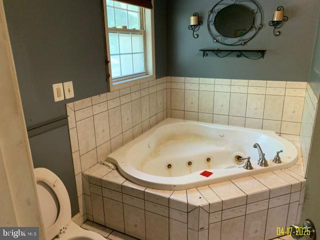 full bathroom featuring a whirlpool tub
