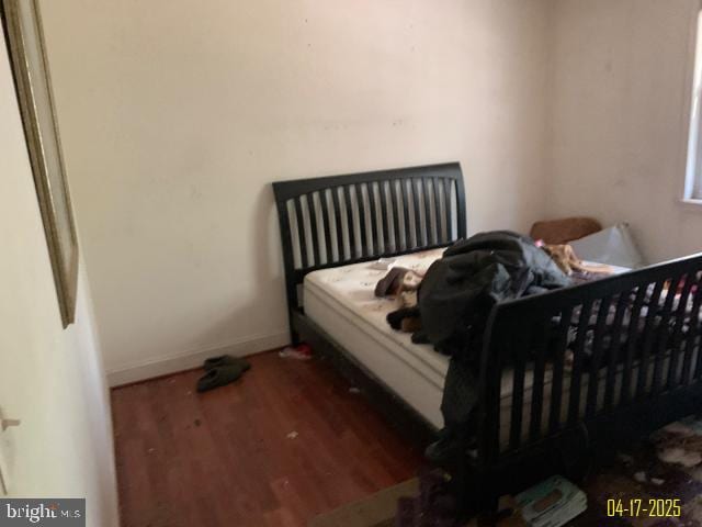 bedroom with wood finished floors and baseboards