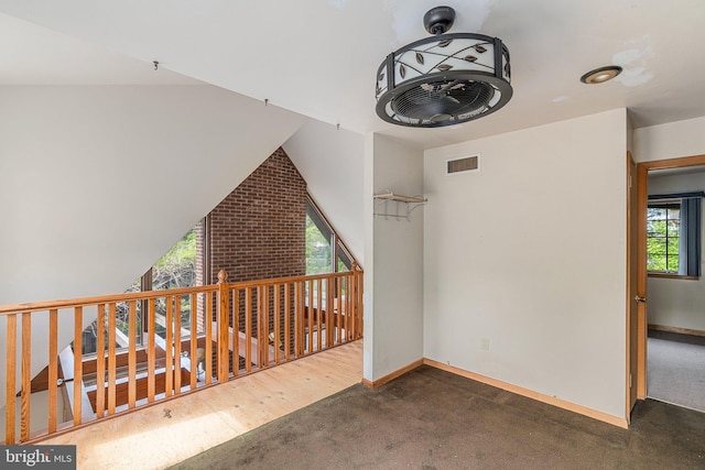 additional living space with baseboards, visible vents, and carpet floors