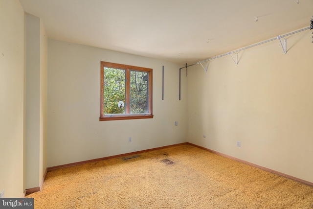 empty room featuring carpet flooring, visible vents, and baseboards