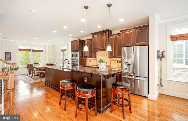 3571 Katherine Way, Frederick, MD 21704 - kitchen featuring stainless steel appliances, ornamental molding, light wood-style floors, baseboards, and a center island with sink
