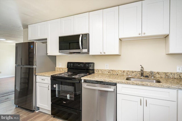 kitchen featuring a sink, white cabinets, appliances with stainless steel finishes, and light wood-type flooring