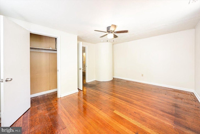 unfurnished bedroom with baseboards, wood finished floors, a ceiling fan, and a closet