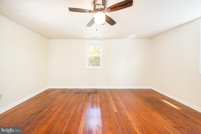 unfurnished room with baseboards, visible vents, wood finished floors, and a ceiling fan