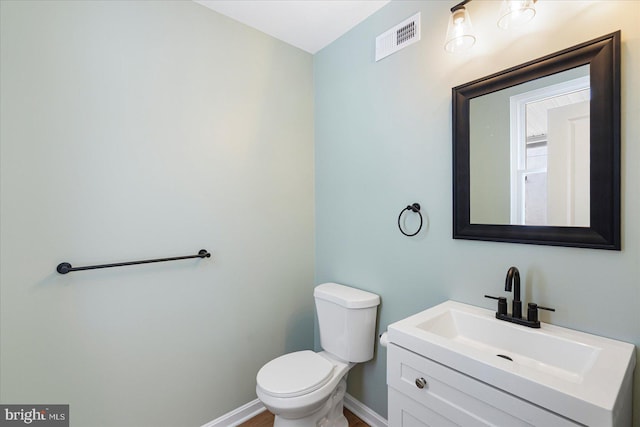 bathroom featuring toilet, baseboards, visible vents, and vanity
