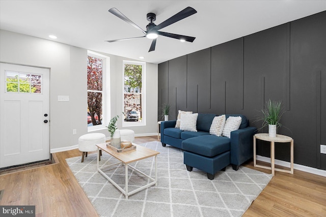 living room with baseboards, a ceiling fan, light wood-style flooring, and recessed lighting