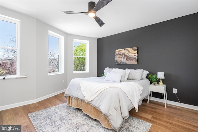 bedroom featuring baseboards, a ceiling fan, and light wood finished floors