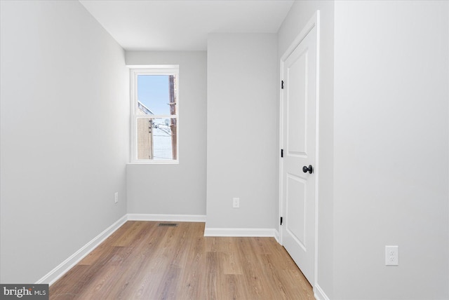 interior space featuring visible vents, light wood-style flooring, and baseboards