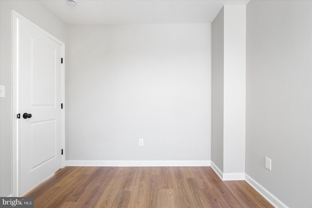 unfurnished room with baseboards and wood finished floors