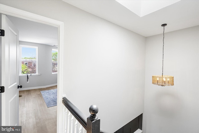interior space featuring baseboards, wood finished floors, and a chandelier