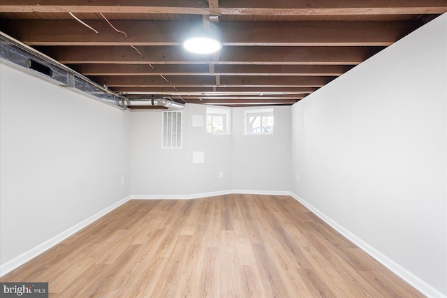 below grade area featuring baseboards and wood finished floors
