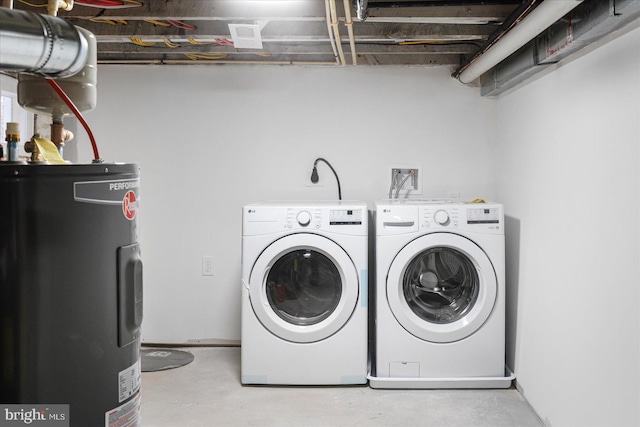 clothes washing area featuring laundry area, washing machine and dryer, and electric water heater