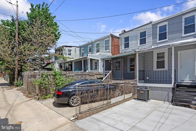 multi unit property featuring fence private yard, central air condition unit, and a porch