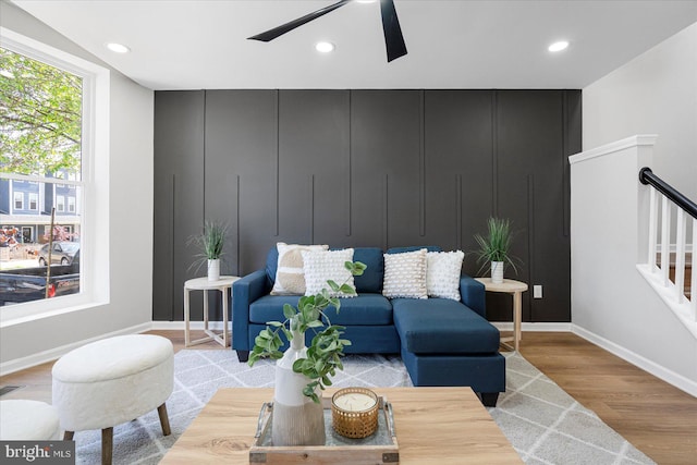 living area featuring a ceiling fan, stairs, wood finished floors, baseboards, and recessed lighting