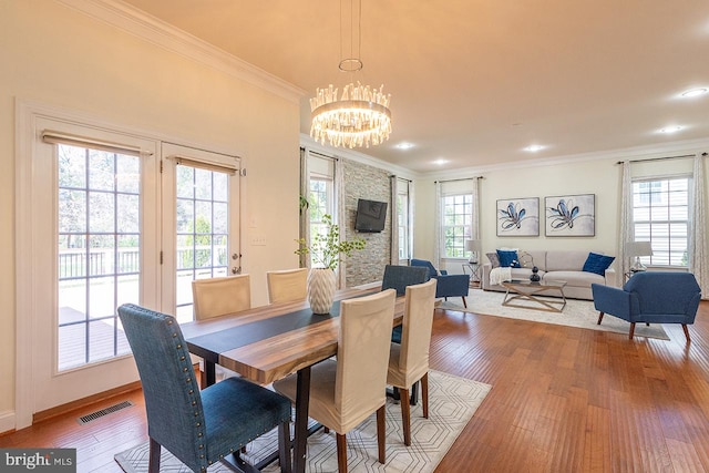 24129 Statesboro Pl, Ashburn, VA 20148 - dining space with light wood-style flooring, baseboards, visible vents, a notable chandelier, and ornamental molding