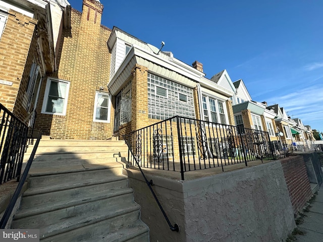 2921 Hale St, Philadelphia, PA 19149 - back of house featuring a chimney, brick siding, and a residential view