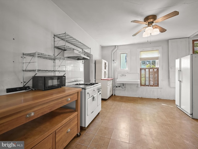 113 Ingleside Ave, Baltimore, MD 21228 - kitchen featuring white appliances, ceiling fan, a wainscoted wall, wooden counters, and a sink